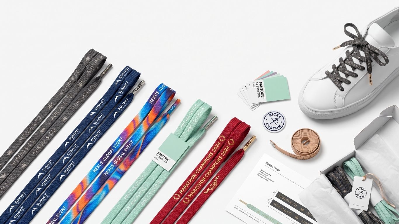 A flat-lay product presentation of a shoe customization kit on a white background, featuring multiple pairs of custom shoelaces in various colors, a white leather sneaker, ribbon, thread, and branding materials.
